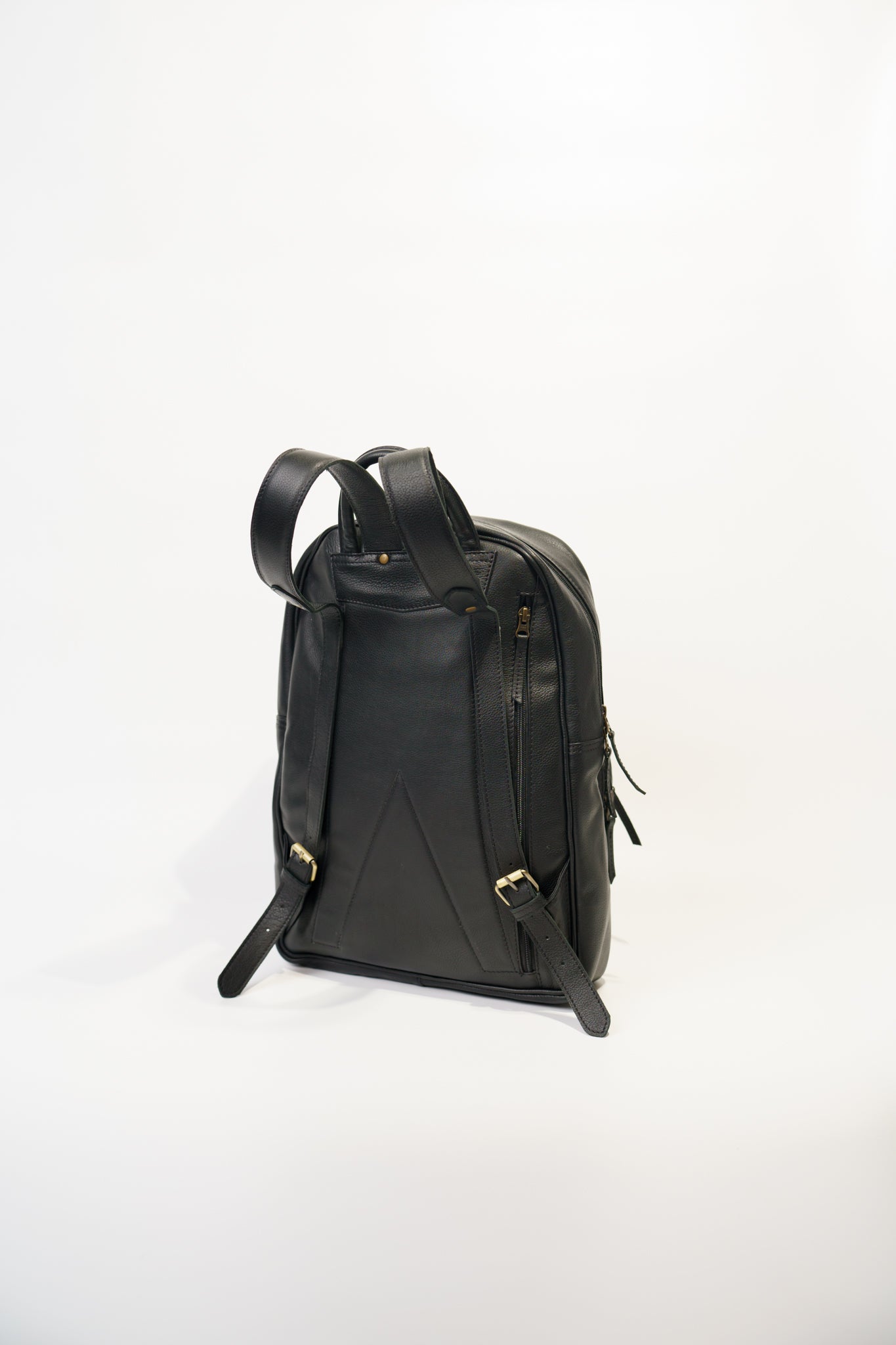 Rear view of Chamra's black leather bag showcasing adjustable shoulder straps with metal buckles.