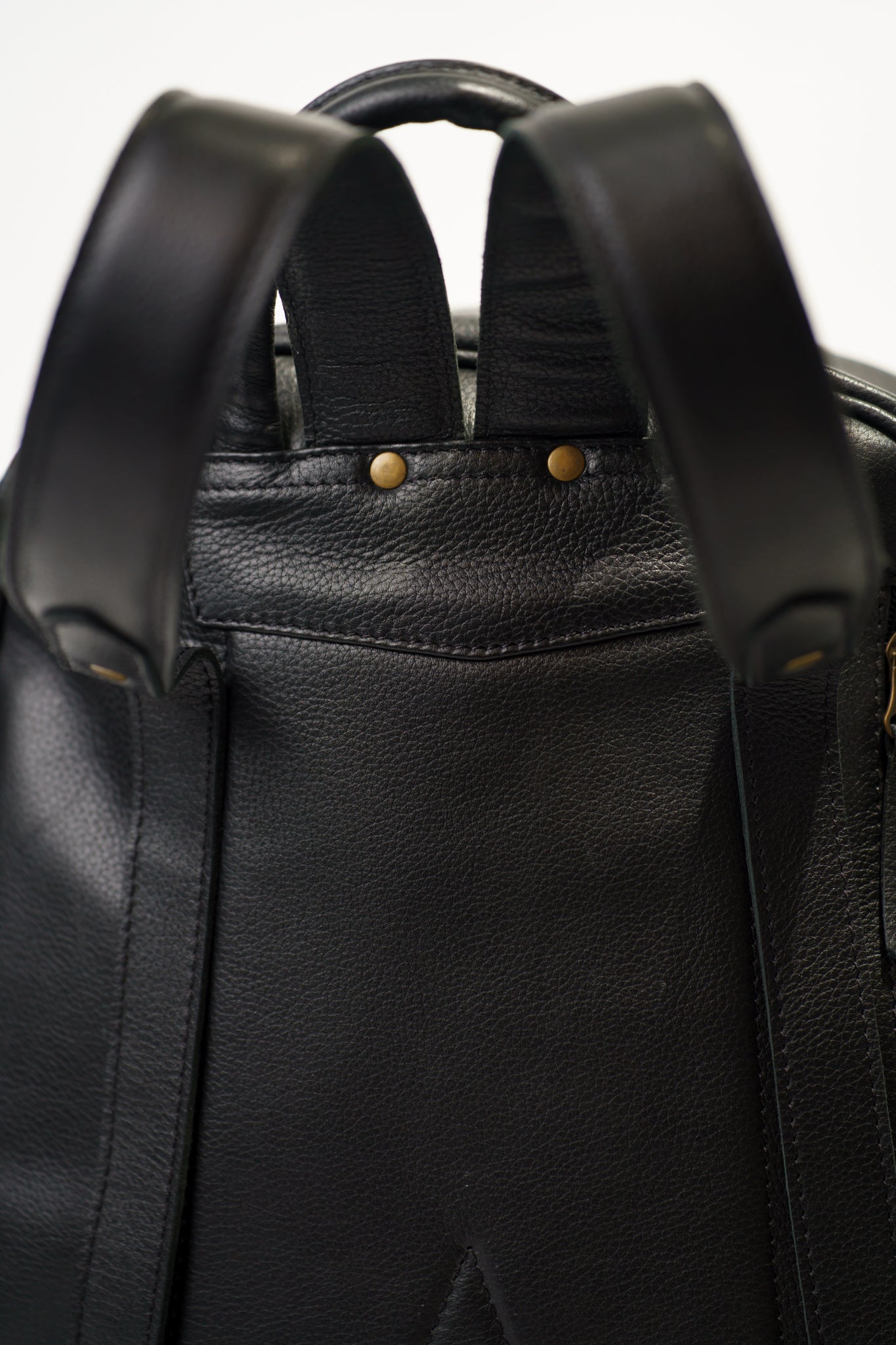 Close-up of the hand carry strap on Chamra's Black leather bag showcasing high quality stitching and attention to detail. 