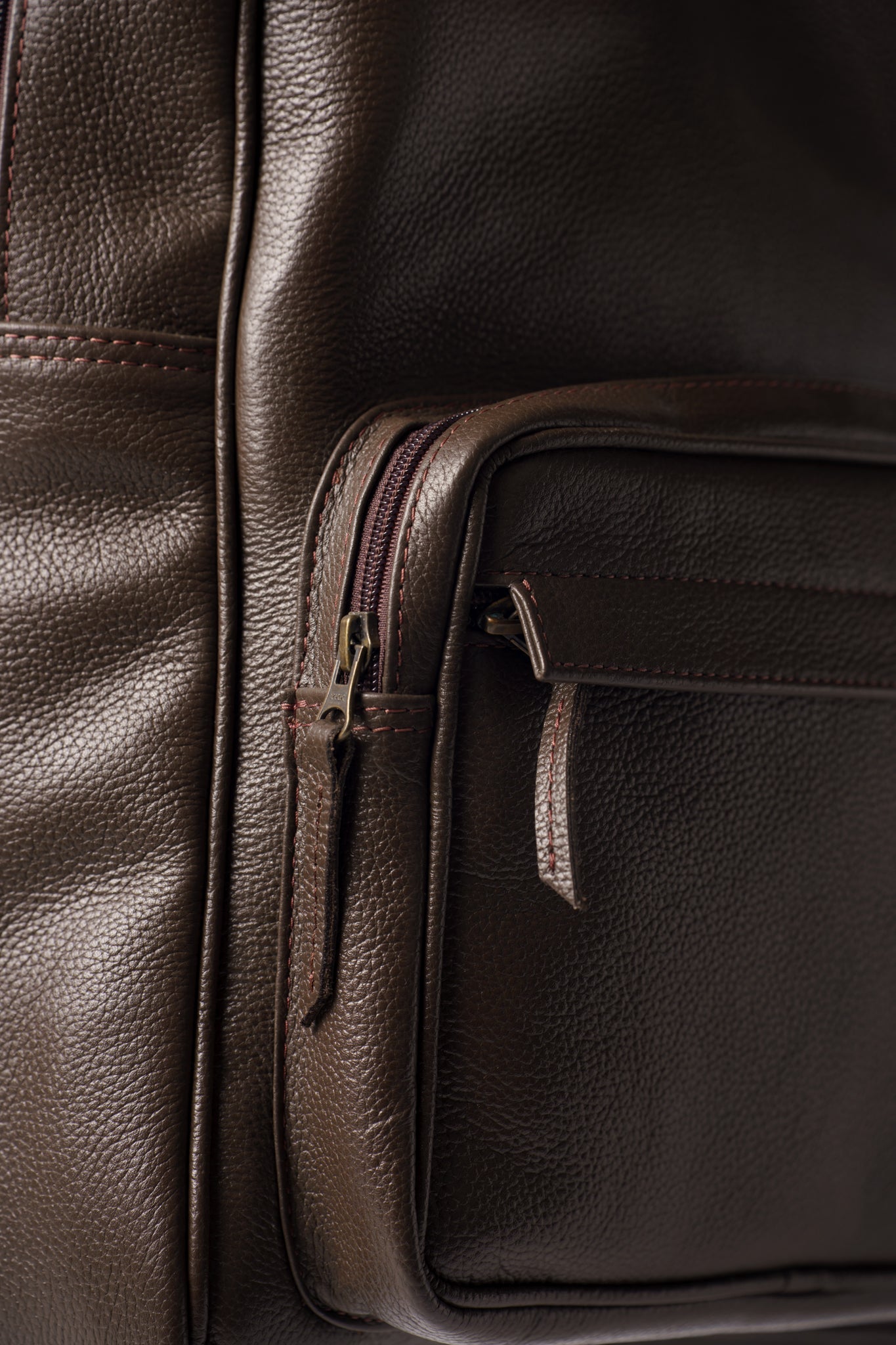 Close-up of Chamra's chocolate brown bag's front rectangular pocket.