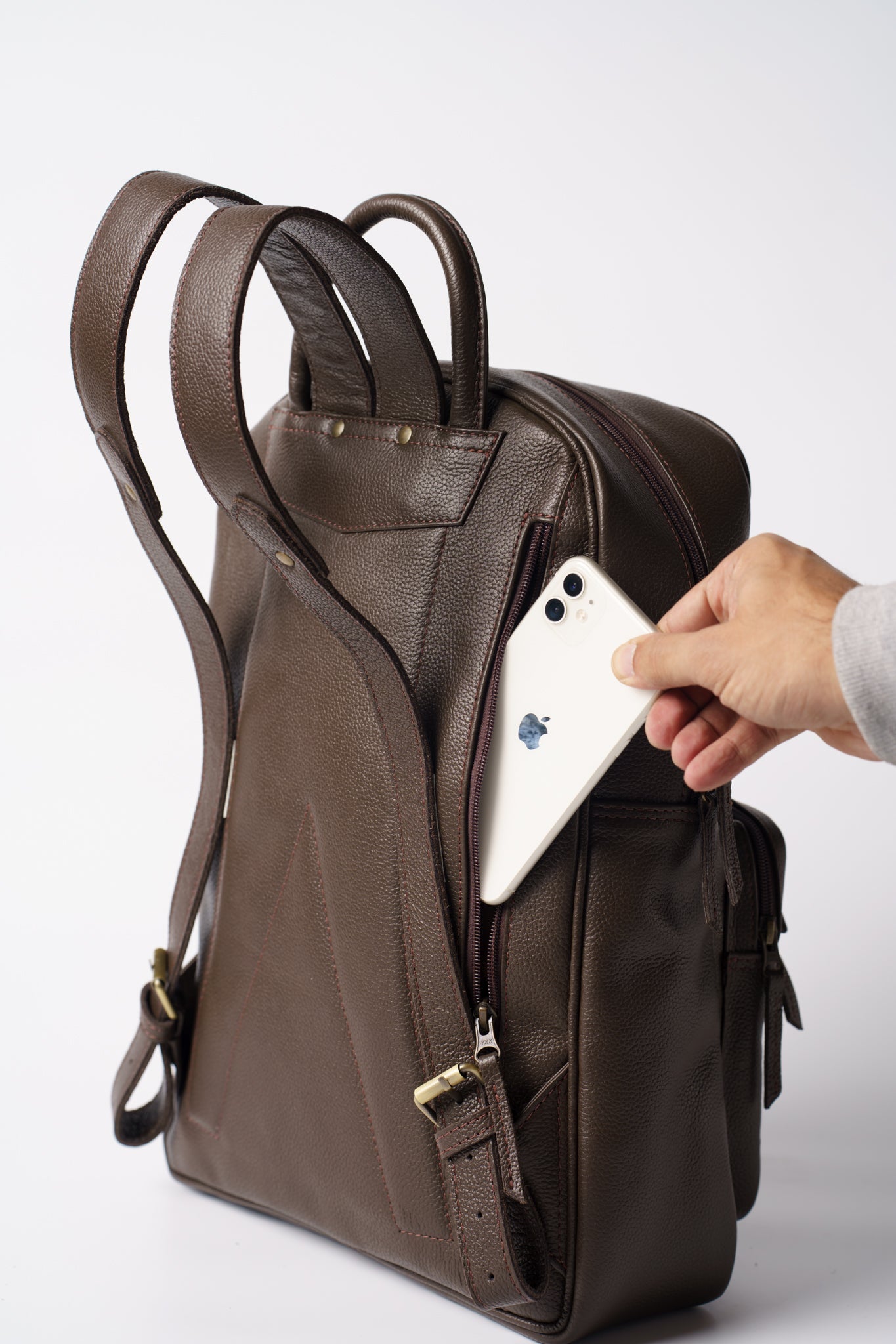 Rear view of Chamra's chocolate brown leather bag, showcasing a sleek compartment for phones behind the shoulder straps. 