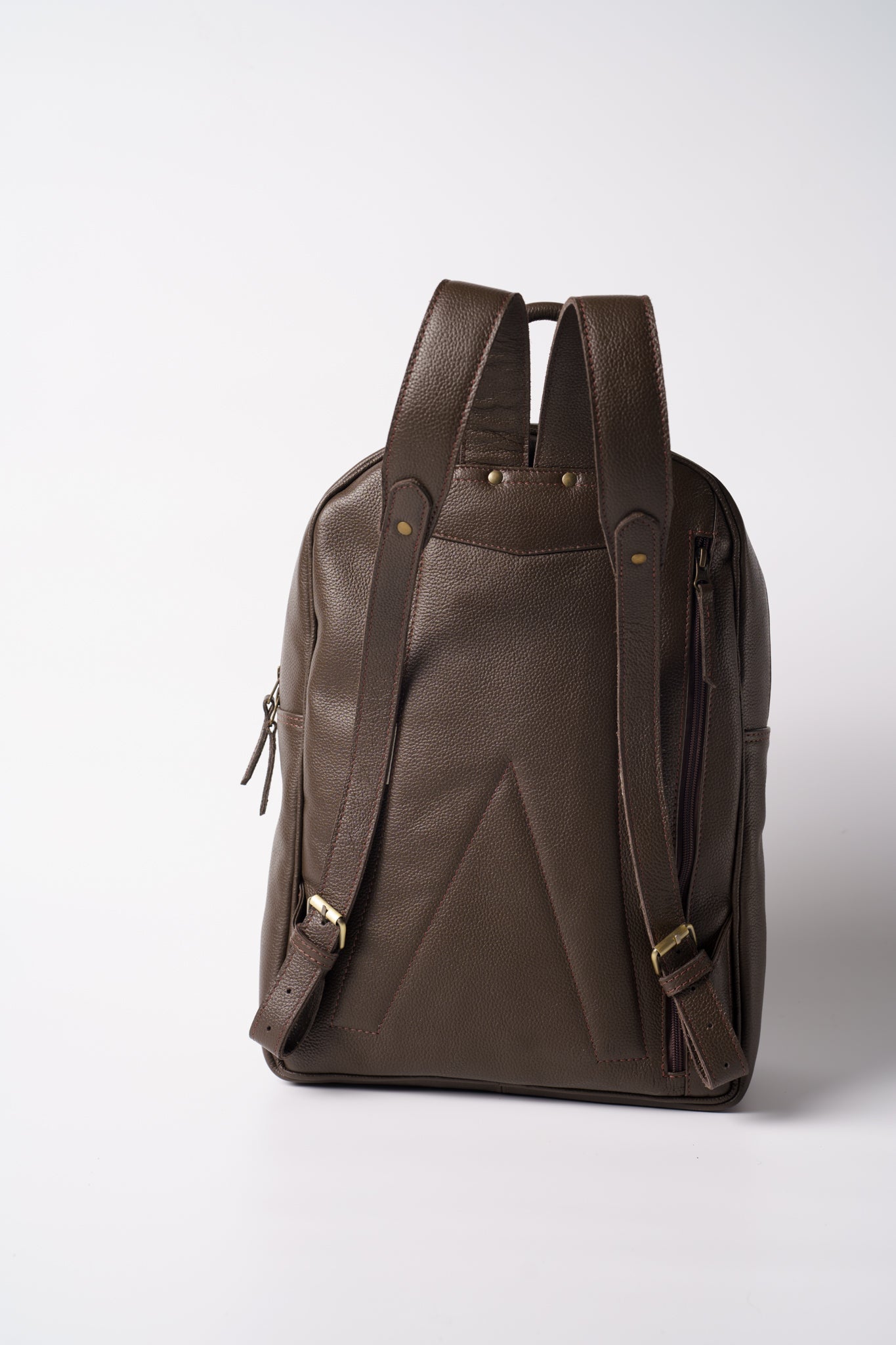 Rear view of Chamra's chocolate brown leather bag. The image showcases the premium hand carry strap and adjustable shoulder straps with metallic buckles and buttons that function to make the bag more durable.