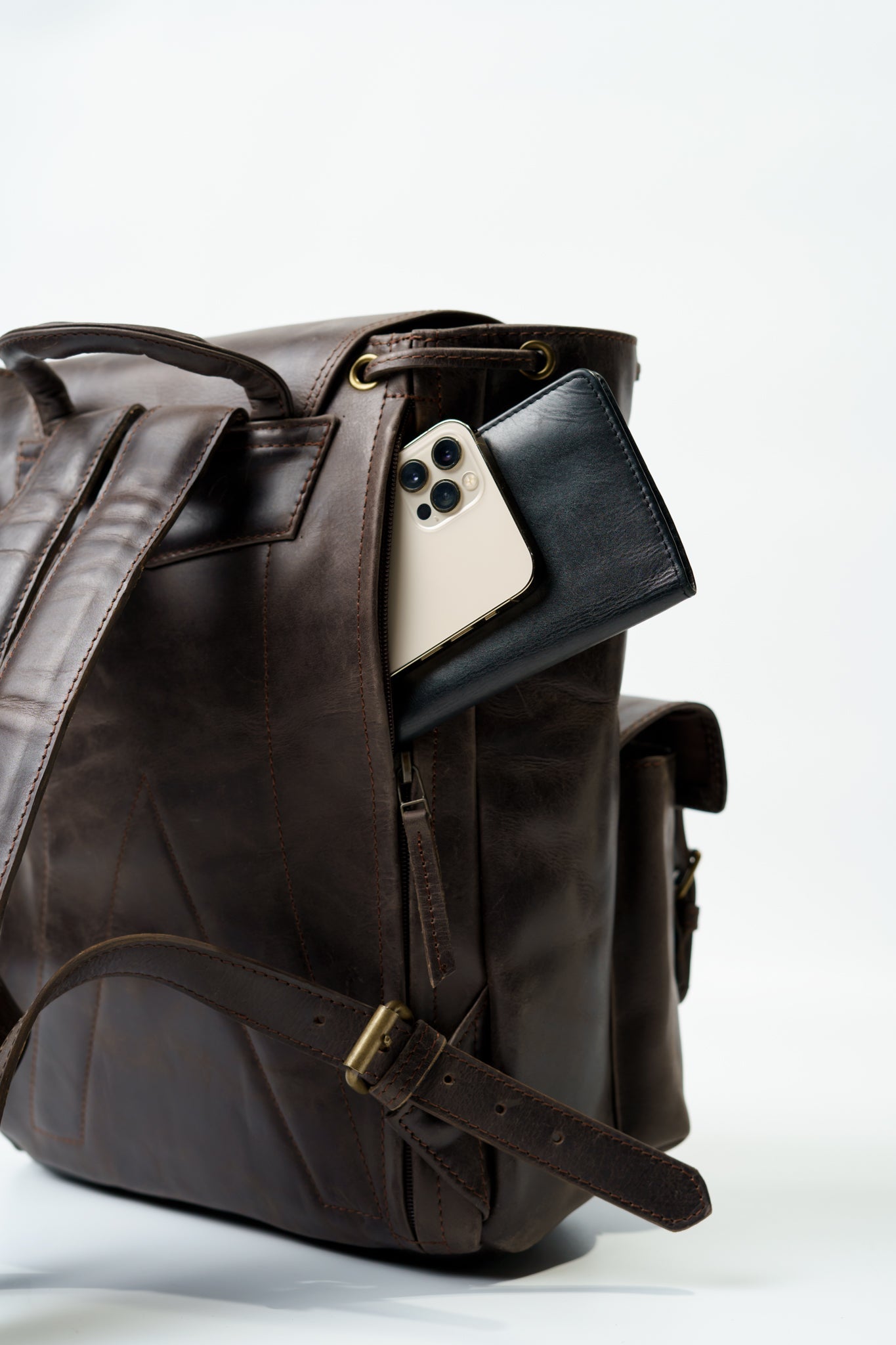 Rear view of Chamra's Utility Brown Backpack showcasing a hidden compartment behind the shoulder straps, fit to carry wallets, phones, passports, or other similar sized items.