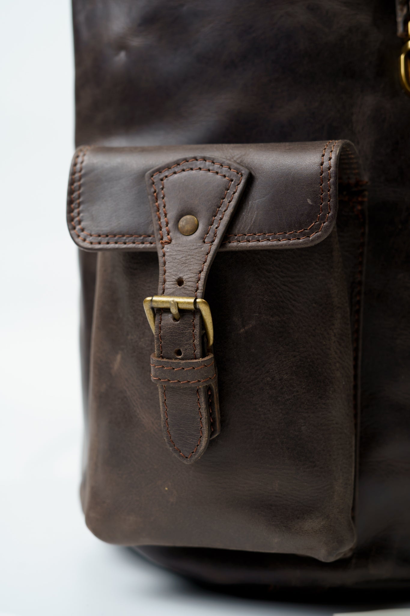 Close-up of the high-quality straps on the outside pockets of Chamra's utility leather backpack.