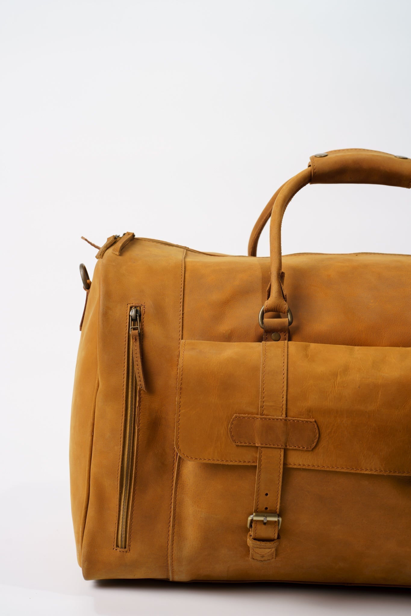 Close-up of the front of Chamra's Matte Leather Duffel Bag with shoe compartment. The close up focuses on another small pocket on the front of the bag, one that has enough room for wallets, passports, phones, or other similar small items.