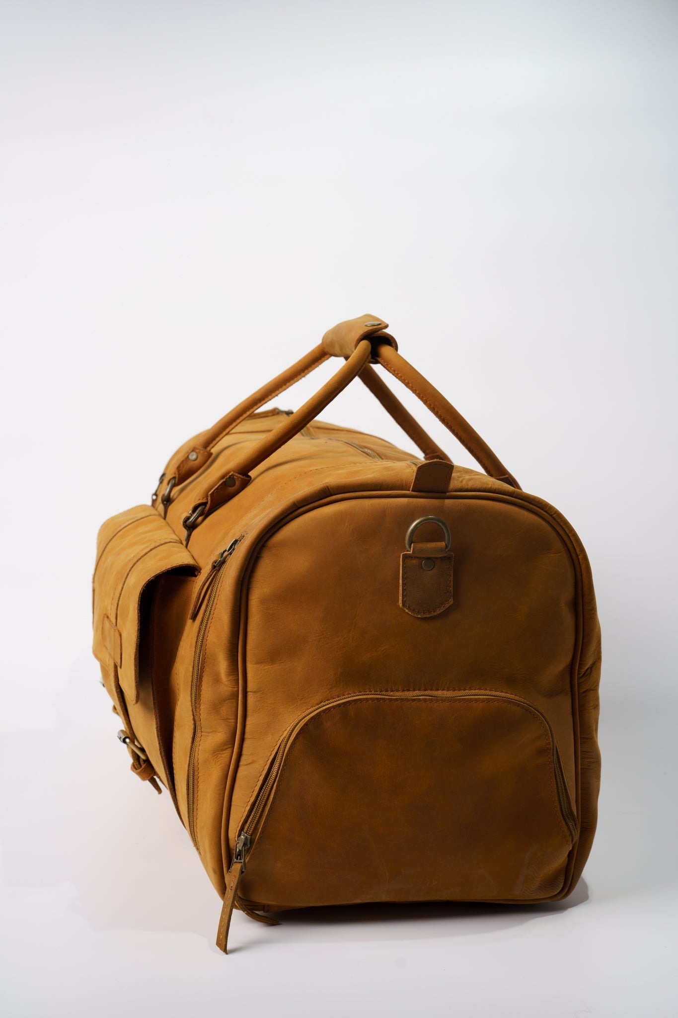 Side view of Chamra's Matte Leather Duffel bag with shoe compartment. This shot showcases the compartment for the shoes on the side of the bag.